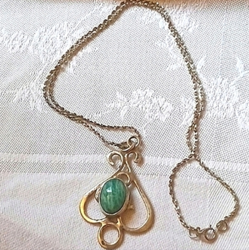 Scrolled silver necklace with green cabochon stone